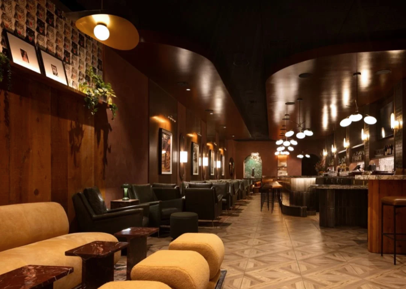 Long view through the warm timber and amber-lit Fox Den cocktail lounge